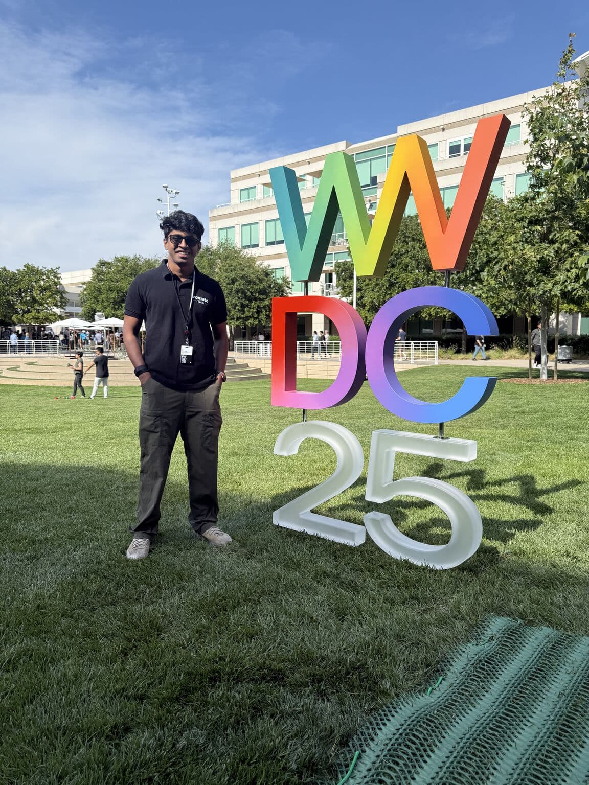 Aakarsh Sasi next to the WWDC25 sign at Apple Park